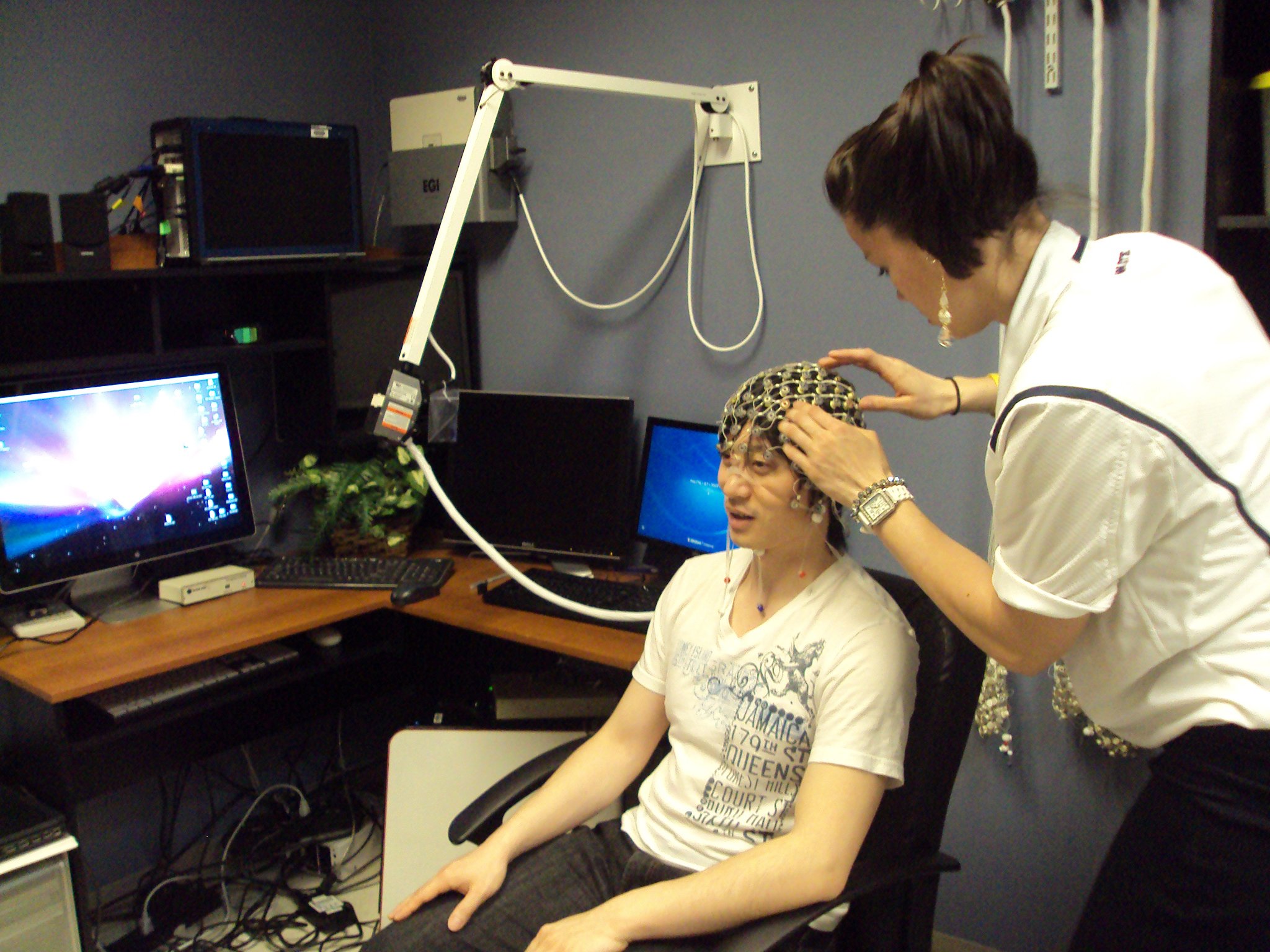 woman fitting EEG cap on volunteer
